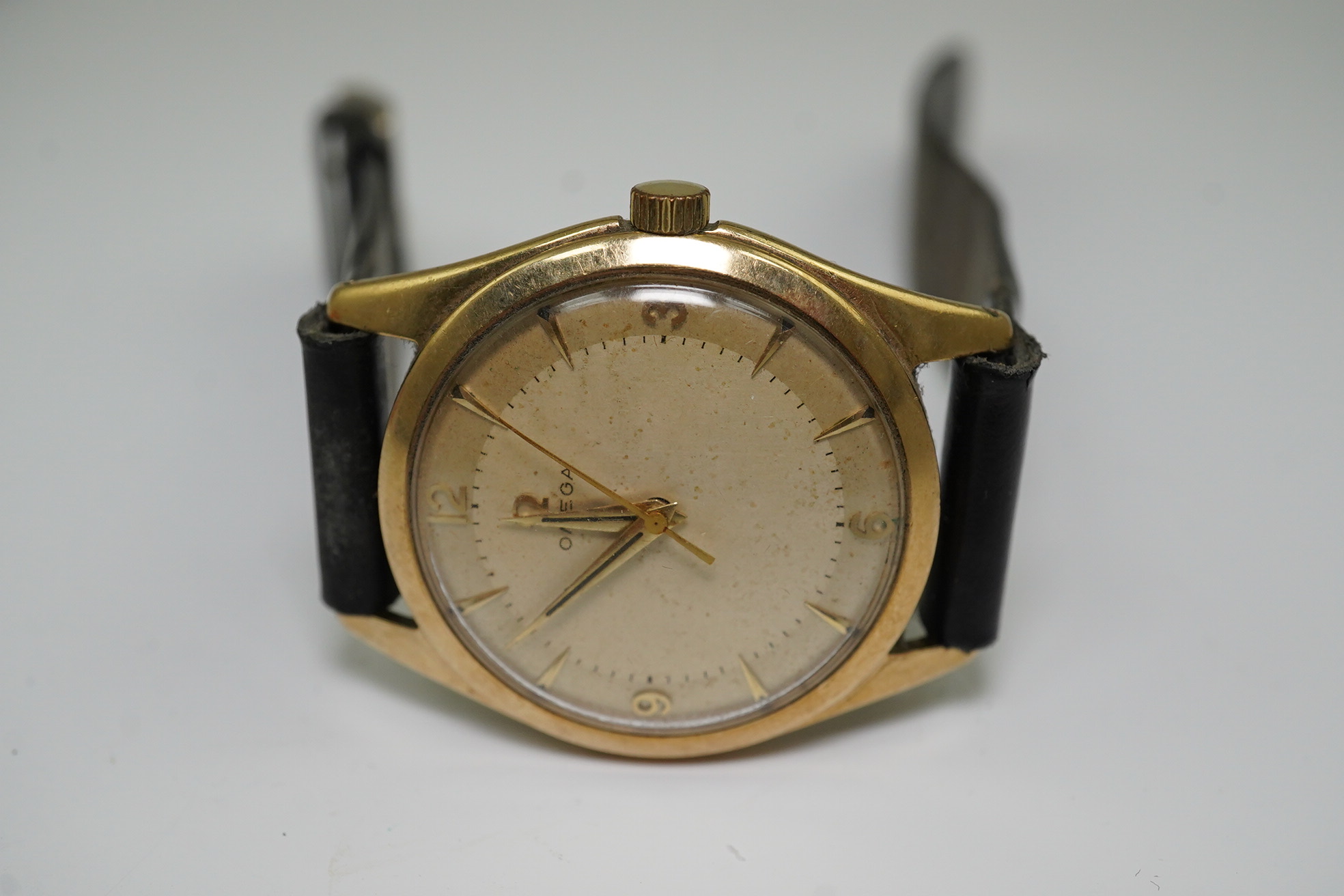 A gentleman's 1950's 9ct gold Omega manual wind wrist watch, with baton and Arabic numerals, movement c.420, case diameter 34mm, on associated leather strap. Condition- poor to fair